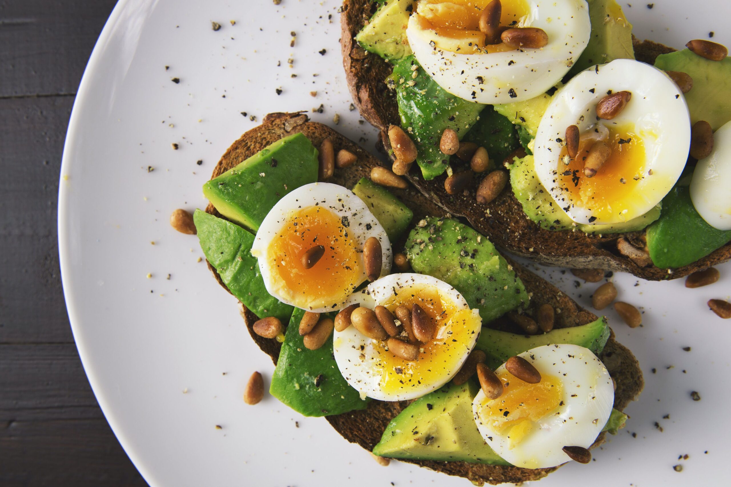 avocado. and eggs on a white plate