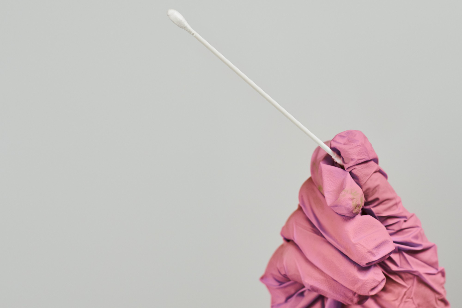 doctor-wearing-pink-gloves-holding-cottonswab-for-the-hpv-test